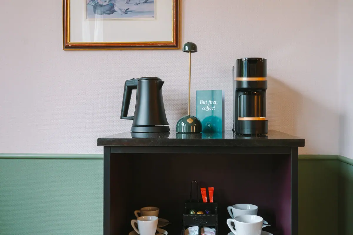 In-room bar with coffee and tea station Coffee machine, kettle and cups on a shelf on one wall.