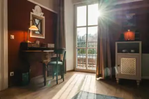 Salon Haus Kaiser HENRI Kitzbühel The Salon hotel room at the HENRI Hotel Kitzbühel with red walls, a desk and a window.