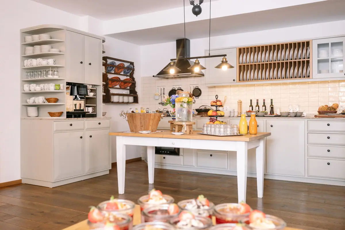 In-house kitchen at the HENRI Kitzbühel Kitchen with a table full of dishes.