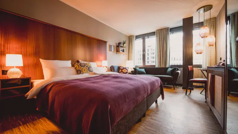 Rooms & Studios at HENRI Düsseldorf Hotel room with bed and table.