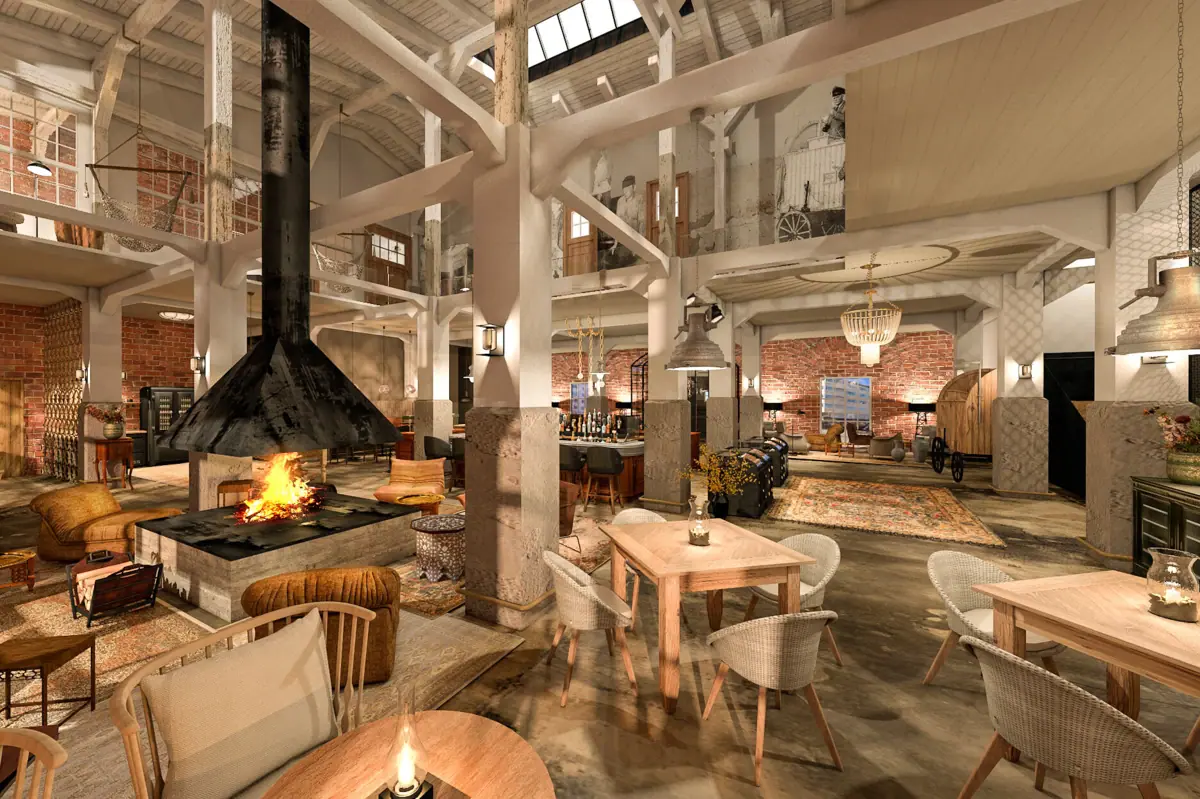 HENRI Cuxhaven living room An open-plan room with high ceilings, several tables, chairs, armchairs and a fireplace.