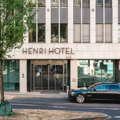 Entrance of the HENRI Hotel Düsseldorf Entrance to the building with a parked car in front of it