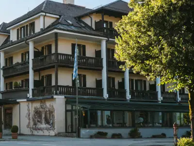 *Opening in summer 2026* From €89 p.p. in double room with breakfast and afternoon snack ("Jause") Sonnenuntergang über einem Gewässer, umgeben von Bäumen und Gras.