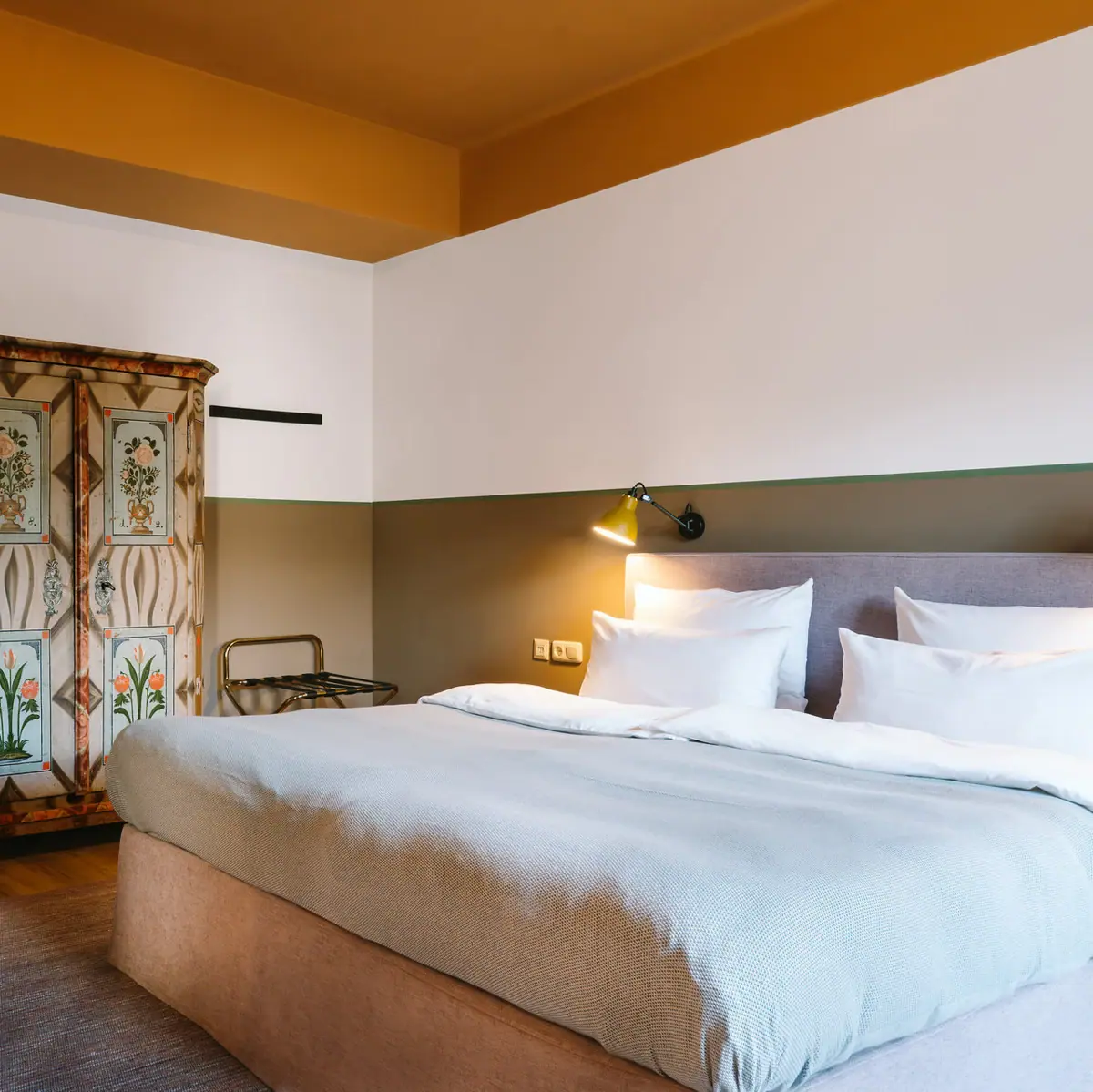 Hotel room HENRI Garmisch-Partenkirchen A room with a bed and a wardrobe.