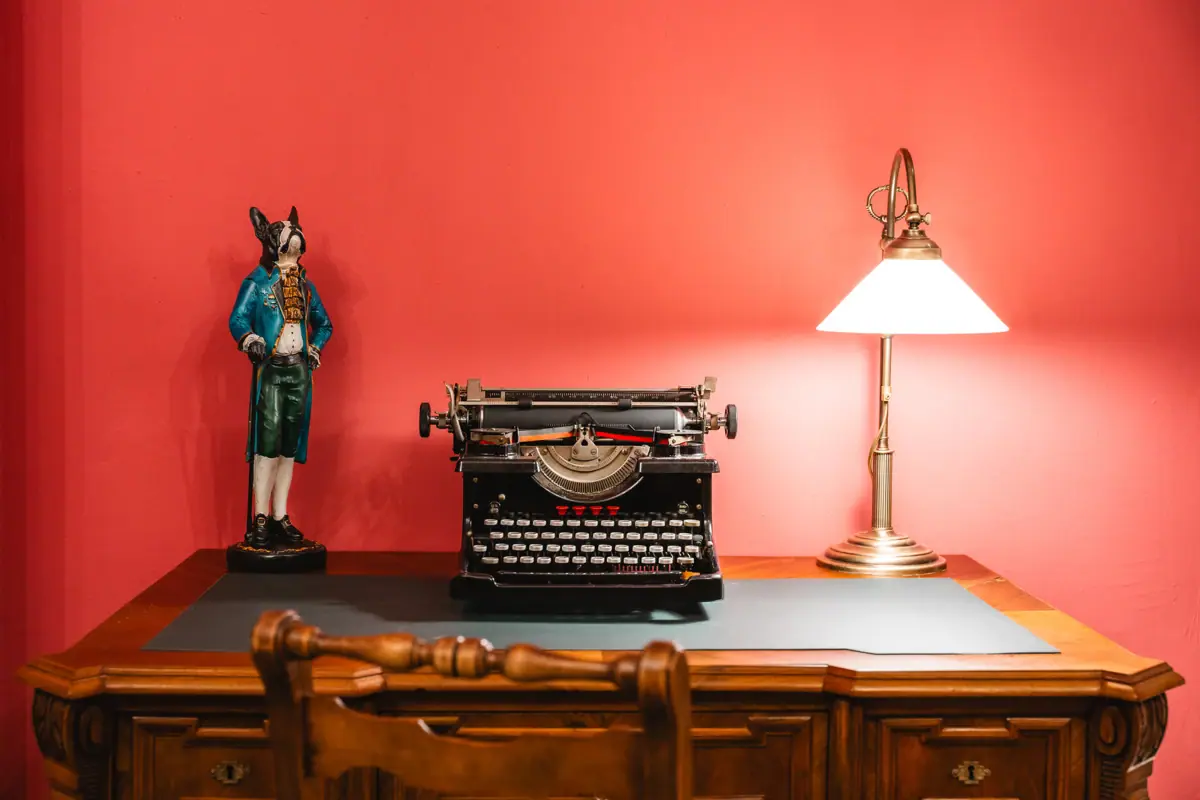 Red Salon A desk with a lamp and a typewriter.