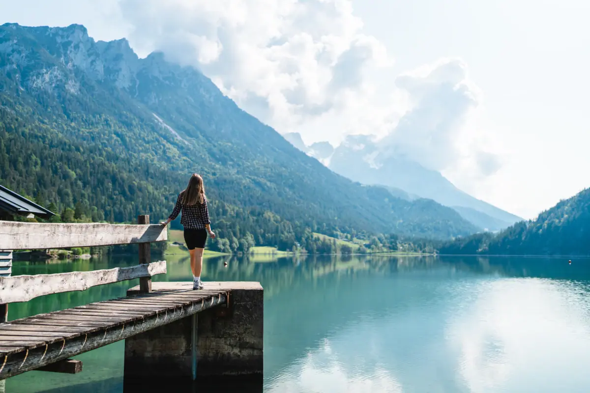 Lake Kitzbühel Lake with jetty and person in front of a mountain backdrop
