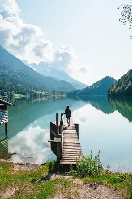 Kitzbühel A woman walks on a footbridge across a lake.