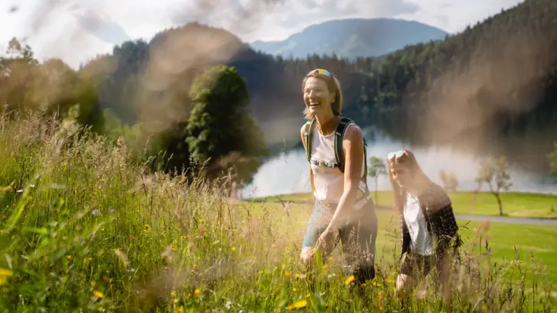 Hikes in the nature of Kitzbühel Two women in a field with grass and plants in the open air.