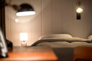 XL-Studio Lamp next to a bed in the interior.