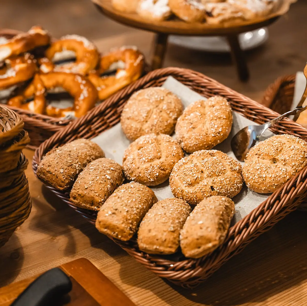 Breakfast at HENRI Several baskets of bread and pretzels on a breakfast buffet.