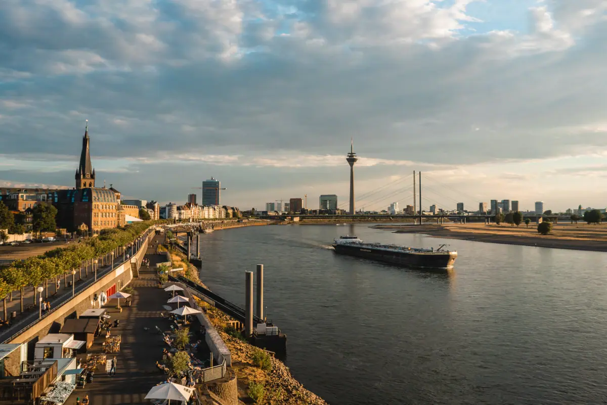 Rhine Promenade A river with a boat on it.