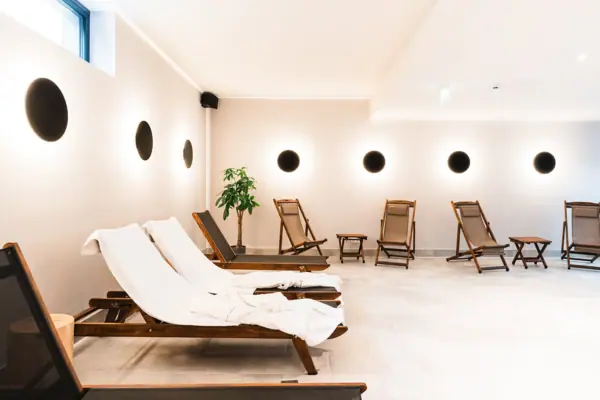 Deckchairs in the pool area A room with chairs and a plant.