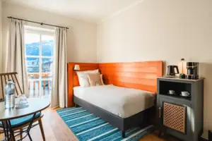 Room with bed Single bed with patio door and small table.