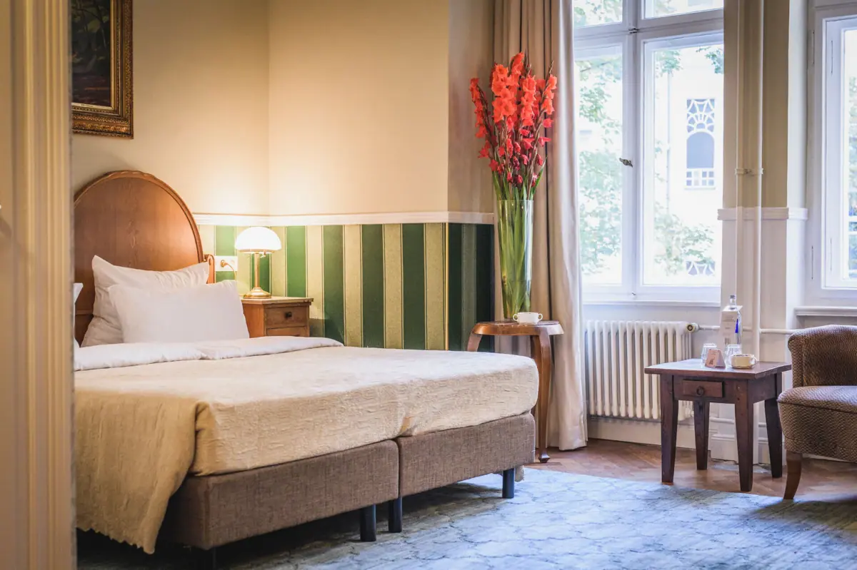 HENRI Berlin Salon Bogota Room with bed and flower vase