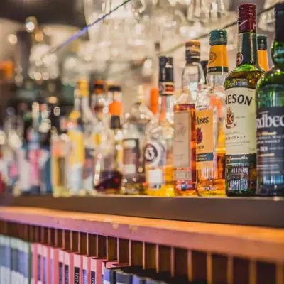 Bar at the HENRI Hotel Hamburg A shelf with bottles of alcoholic drinks.