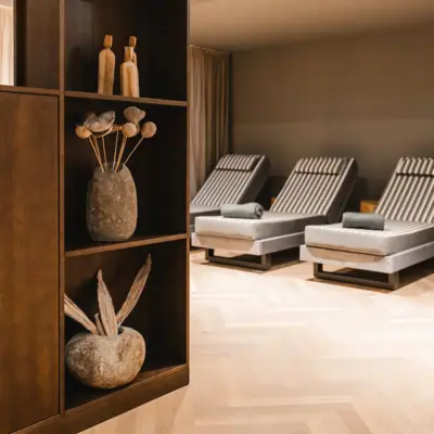 Relaxation room at the HENRI Hotel Kitzbühel A room with a shelf and chairs.