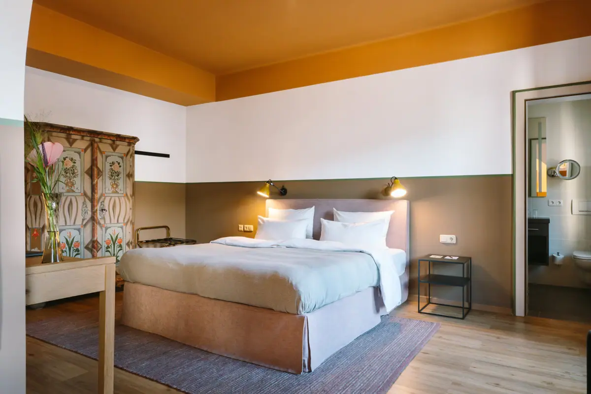 Hotel rooms at the HENRI Garmisch-Partenkirchen A bed in a hotel room with a stylish interior design.