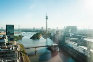 Düsseldorf River with a bridge and city skyline featuring a prominent tower.