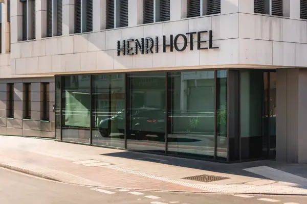 HENRI Düsseldorf A building with glass windows.