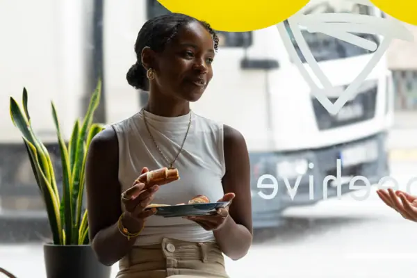 A woman who works A woman sits on a windowsill and eats.