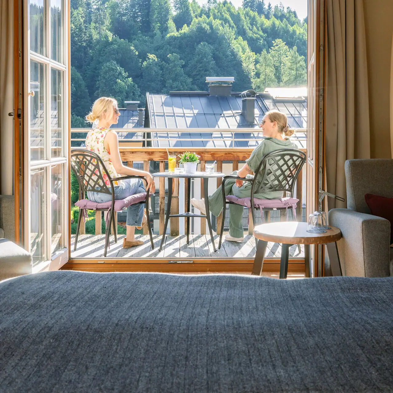 Room with balcony Two women sit on a balcony and look out of a window.