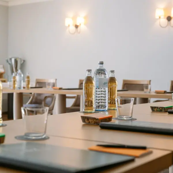 Covered conference table A table with bottles and glasses on it.