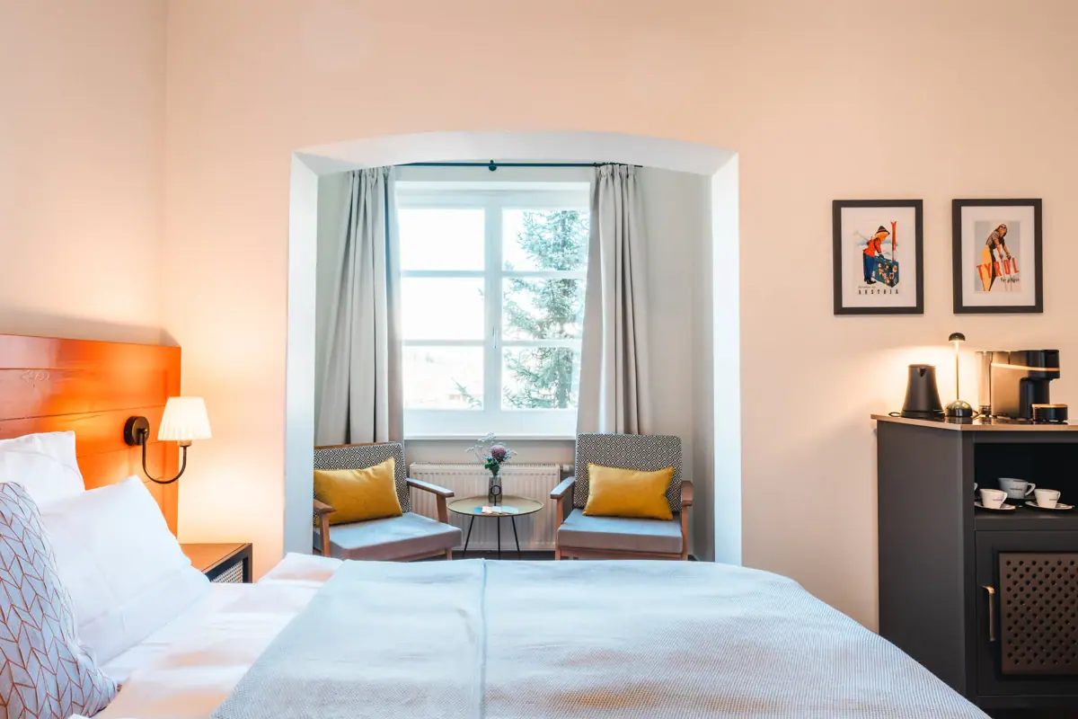 Rooms in Haus Streif A bedroom with a bed, chairs and pillows.