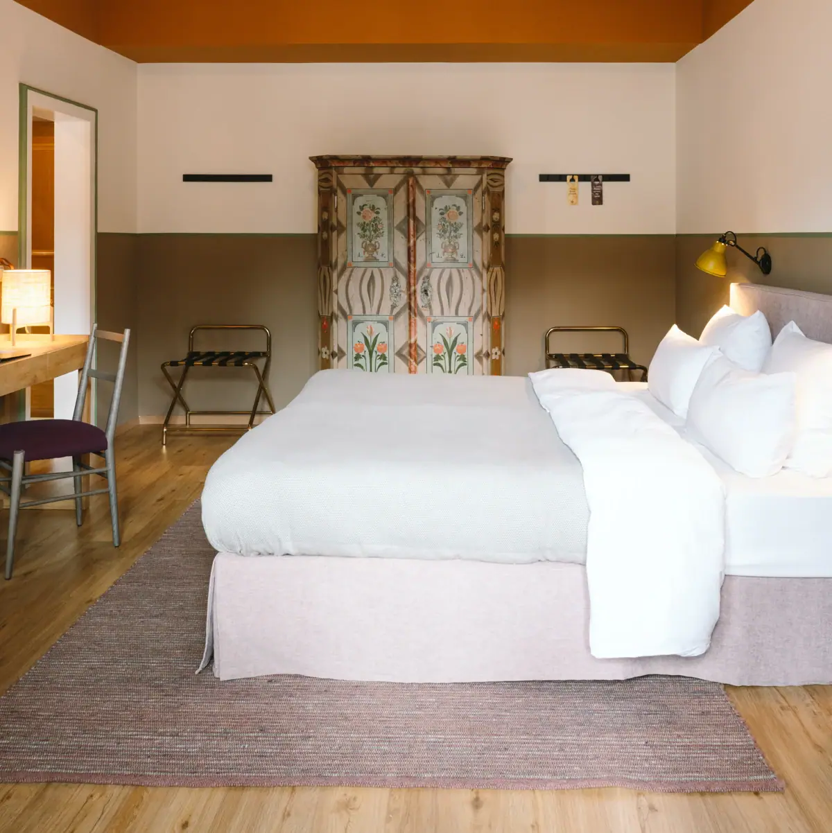 Room HENRI Garmisch-Partenkirchen A beautiful hotel room at the HENRI Garmisch-Partenkirchen with a bed and a desk.