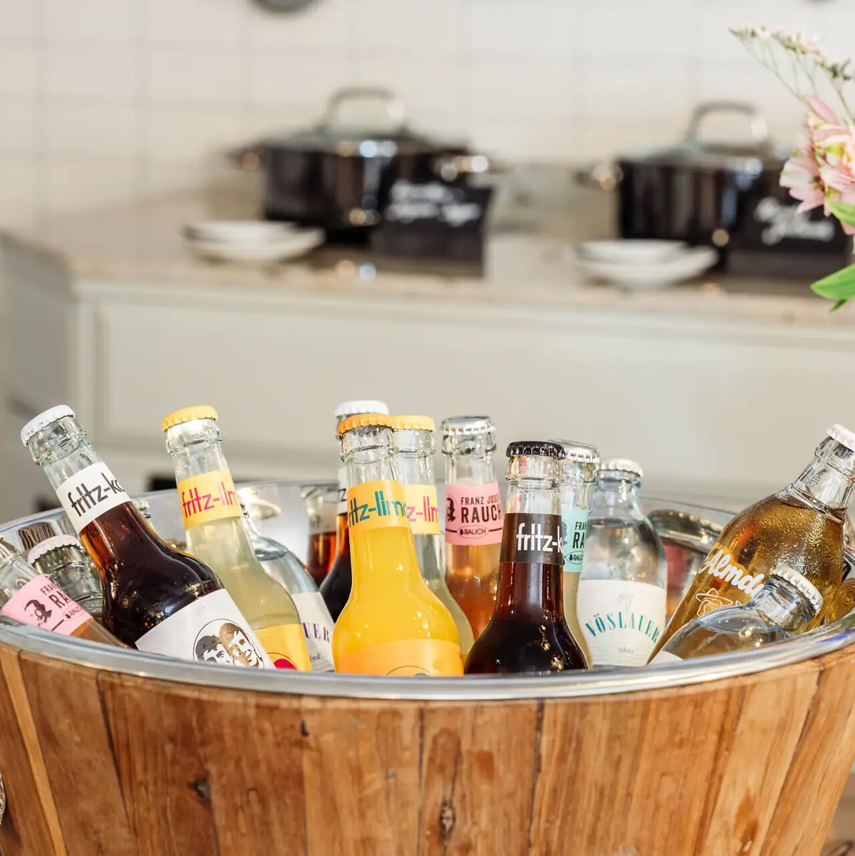 Bucket filled with drinks bottles A bucket of bottles in a kitchen.