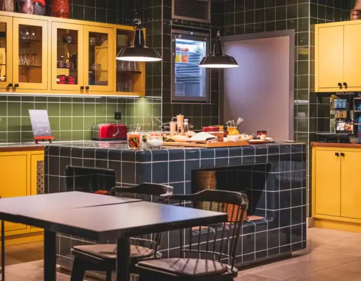 Eating and drinking at HENRI Düsseldorf Kitchen with yellow cupboards and a worktop