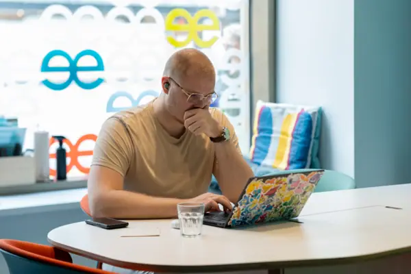 Man at work A man sits at a table and supports his face with his hand.