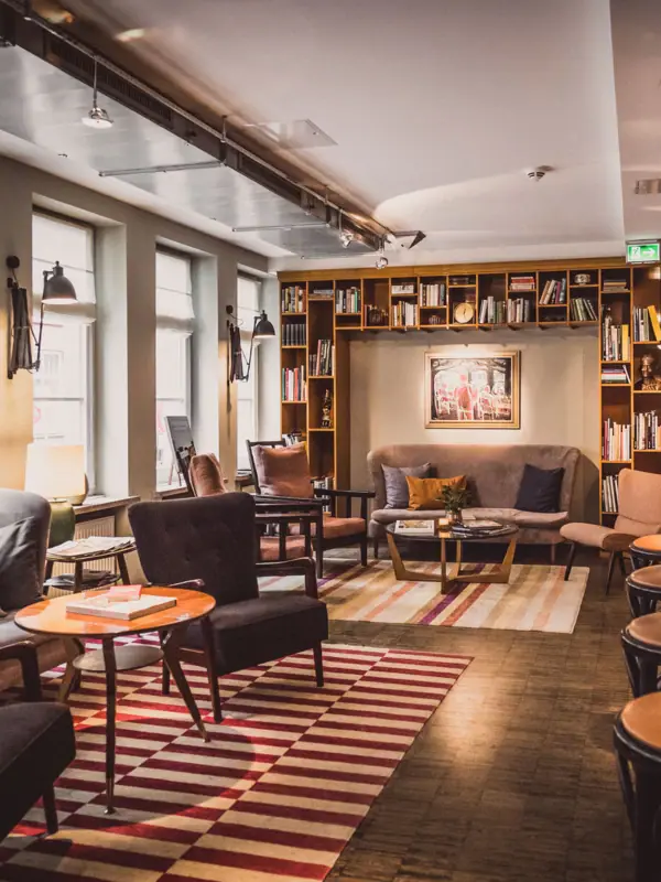 Lounge area at the HENRI Hotel Hamburg Seating groups consisting of armchairs, tables and a sofa in the lounge area.