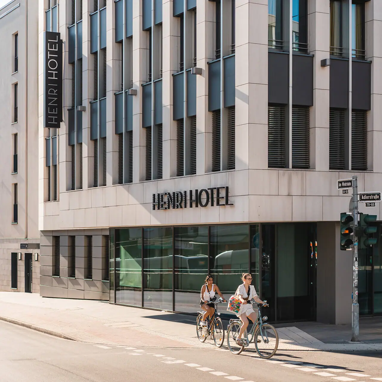 HENRI Hotel Düsseldorf A group of people riding bicycles in front of a hotel.