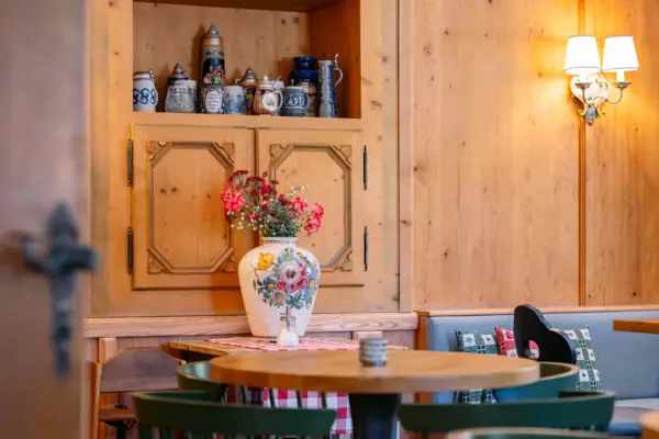 Klausner Stube in the HENRI Hotel Kitzbühel A table with a vase full of flowers on it.