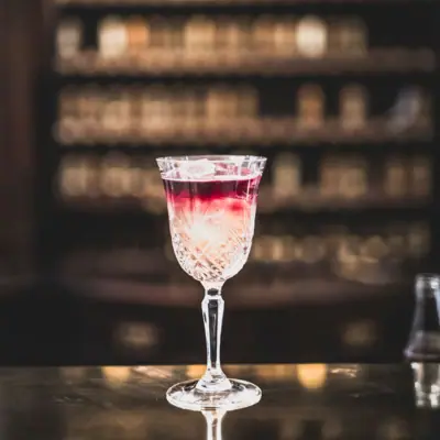 HENRI Berlin Drinks A glass with a drink on a bar.