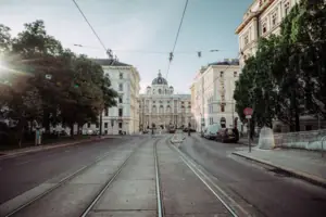 Street in Vienna Train tracks in a city with buildings and trees nearby.