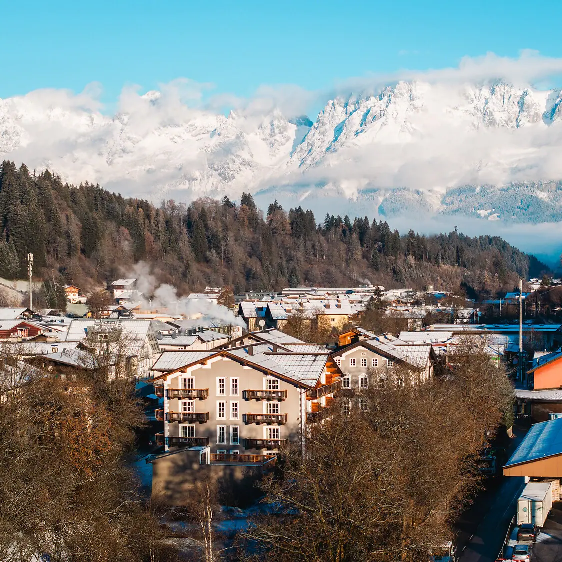 HENRI Kitzbühel with snow-covered mountains Mountain village with snow-capped mountains in the background.