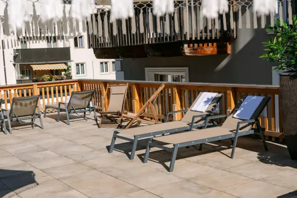 Sun terrace A terrace with chairs and a white parasol.