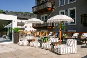 HENRI Kitzbühel SPA Terrasse Terrasse mit Stühlen und Sonnenschirmen