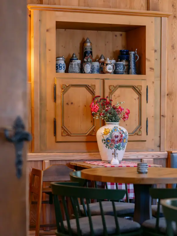 Cupboard with beer mugs Vase with flowers on a table