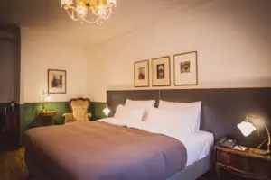 Room view A bed with a chandelier and pictures on the wall.