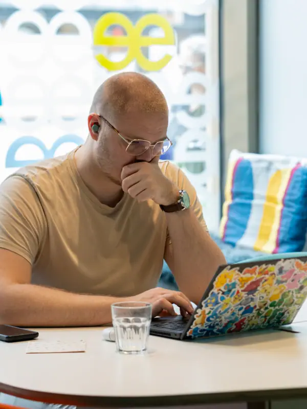 Beehive Düsseldorf A man sits at a table and supports his face with his hand.