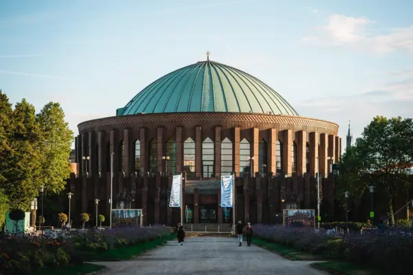 Tonhalle Düsseldorf A building with a dome and people walking in front of it.