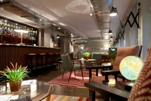 Reception and lounge area at HENRI Hamburg A room with a bar and armchairs.